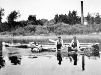 Figure 4. U.S. Bureau of Fisheries staff examining a juvenile mussel culture basket in a pond at the Fairport Biological Station, probably in 1919 (from Coker etal., 1921).